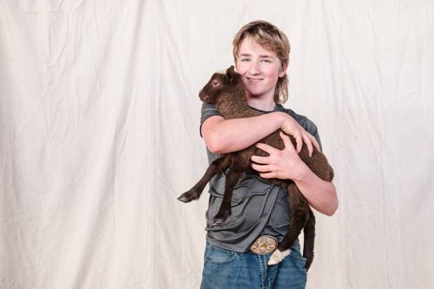 Creative Highlights Symbolbilder Happy teenage boy holding a brown lamb. Clearwater, Minnesota, United States R_RDOL240331-1382466-01 ,model released, Symbolfoto