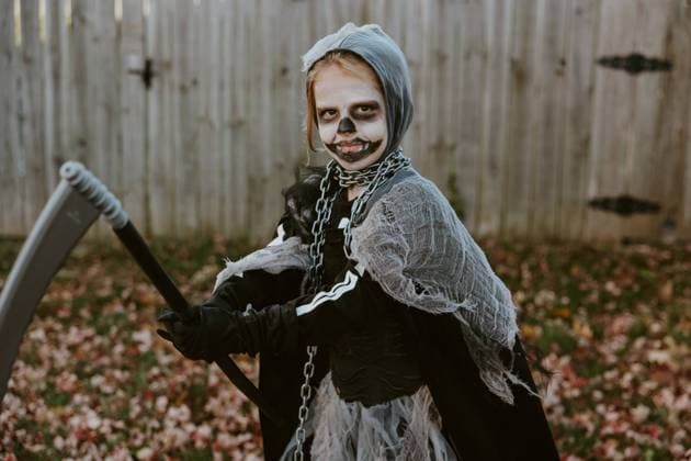 Child in Grim Reaper Halloween Costume in yard with Fall Leaves Lincoln, Nebraska, United States R_LTRZ240331C6-1383489-01 ,model released, Symbolfoto