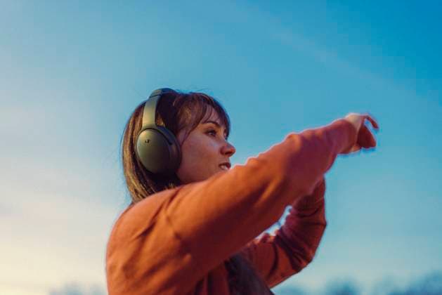 Creative Highlights Symbolbilder Young woman wears headphones and dances to music at sunset. Petersburg, Virginia, United States R_TYRI240402-1384280-01 ,model released, Symbolfoto