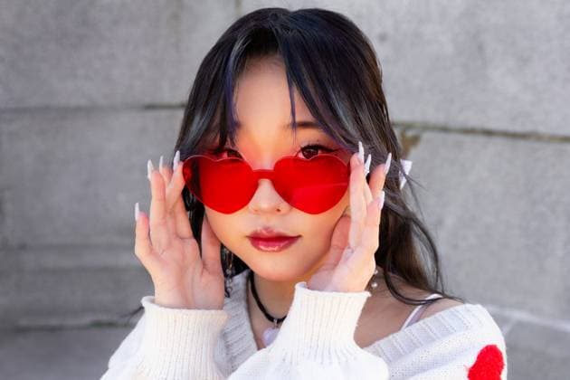 Creative Highlights Symbolbilder MR_ID20266_16680_LuoYiZhou.jpg A stylish Gen-Z chinese girl poses with red heart-shaped sunglasses, exuding a contemporary and fashionable vibe Model Released GemaAlejo_ID20266_599293_003 Copyright: xGemaxAlejox RECORD DATE NOT STATED