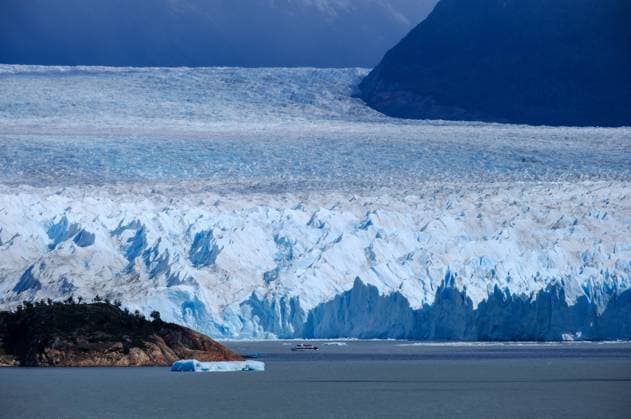 El Calafate, Patagonien, Argentinien - Perito Moreno Gletcher im Nationalpark Los Glaciares. Der Perito Moreno Gletscher gehoert zum patagonischen Eisfeld, dem Campo Hielo Sur, der drittgroessten Suesswasserreserve der Welt. Er liegt in der Provinz Santa Cruz am Lago Argentino, dem groessten See des Landes. Der Perito Moreno Gletscher ist bis zu 30 km lang und 5 km breit. Seine Abbruchkante ist an der hoechsten Stelle 70 m hoch. Vom Gletscher abgebrochene kleine Eisberge treiben im Lago Argentino. Der Gletscher gehoert zu den schoensten Sehenswuerdigkeiten Suedamerikas und gilt als eine der meistbesuchten Attraktionen Argentiniens. Mit einem Ausflugsboot fahren Touristen an den Gletscher heran. El Calafate Patagonien Argentinien *** El Cala