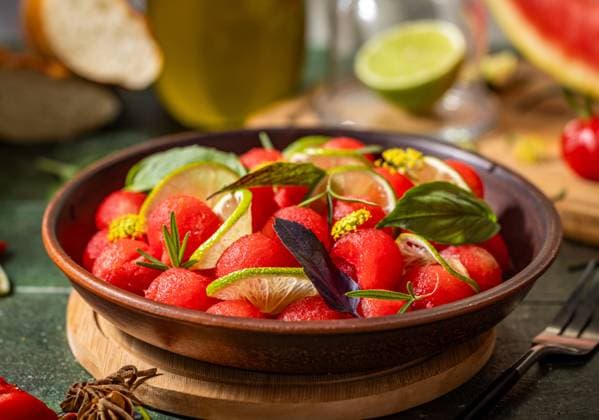 Spicy salad of fresh watermelon balls with basil, lime, rosemary and fennel, topping with olive oil Spicy salad of fresh watermelon balls with basil, lime, rosemary and fennel, topping with olive oil on dark green table surface with sunny light Copyright: xZoonar.com VictoriaxKondysenkox(ArtSvitlyna)x 20788101