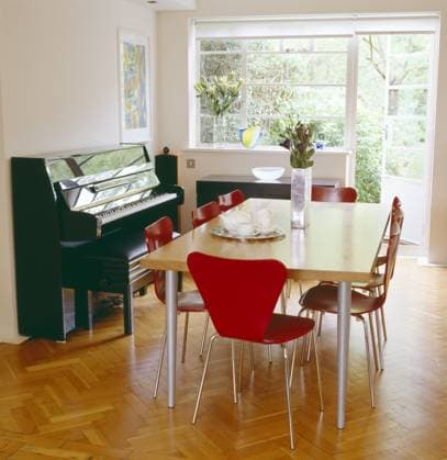 A modern white dining room wood table red Arne Jacobsen style chairs piano wood parquet flooring A modern white dining room wood table red Arne Jacobsen style chairs piano wood parquet flooring, Credit:Niall McDiarmid Avalon  Copyright: xNiallxMcDiarmidx xAvalonx 0544845536