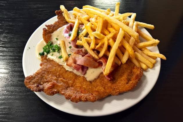 Gastronomie: Paniertes Jägerschnitzel mit Pommes. Das Jägerschnitzel ist ein Gericht der österreichischen Küche. Es ist eine Ableitung des Naturschnitzels, die normal ohne Panade serviert wird. Im deutschsprachigen Raum versteht man darunter auch oft ein paniertes Kalbs- oder Schweineschnitzel mit einer Pilzsauce *** Gastronomy Breaded Jägerschnitzel with fries The Jägerschnitzel is a dish of Austrian cuisine It is a derivative of the natural schnitzel, which is normally served without breading In German-speaking countries, it is also often understood to mean a breaded veal or pork schnitzel with a mushroom sauce