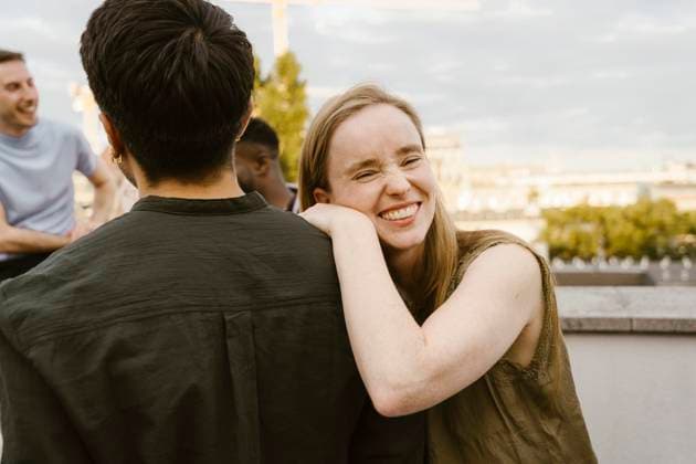 Portrait of smiling woman laughing while leaning on male friend s shoulder at party Germany, Berlin, model released, property released Copyright: xMaskotx , MA108163 MA108163