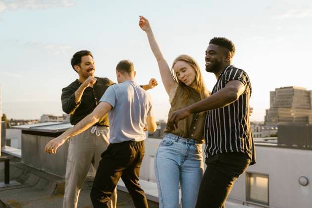 Carefree group of male and female friends dancing together on building terrace Germany, Berlin, model released Copyright: xMaskotx , MA108181 MA108181