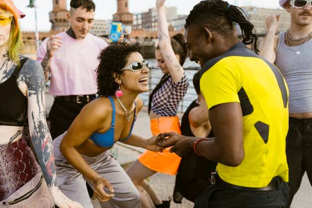 Happy non-binary person wearing sunglasses and dancing with friends in city Germany, Berlin, model released Copyright: xMaskotx , MA108330 MA108330