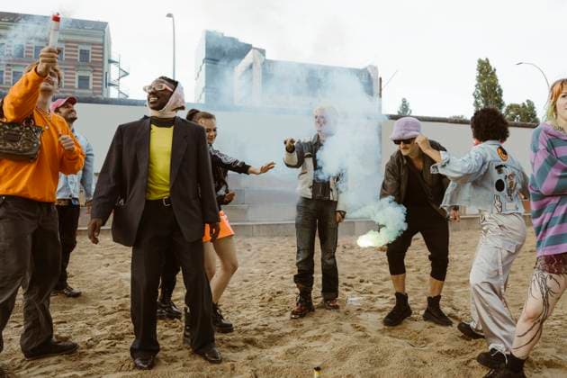 Creative Highlights Symbolbilder Carefree non-binary friends burning distress flare while standing on sand at park Germany, Berlin, model released Copyright: xMaskotx , MA108342 MA108342