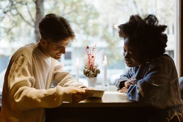 Boyfriend and girlfriend reading menu card while sitting at bar Germany, Berlin, model released, property released Copyright: xMaskotx , MA108408 MA108408