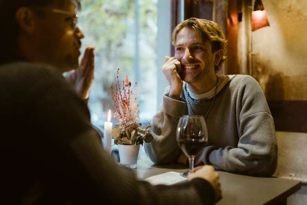 Happy gay man talking with boyfriend during candlelight date at restaurant Germany, Berlin, model released, property released Copyright: xMaskotx , MA108445 MA108445