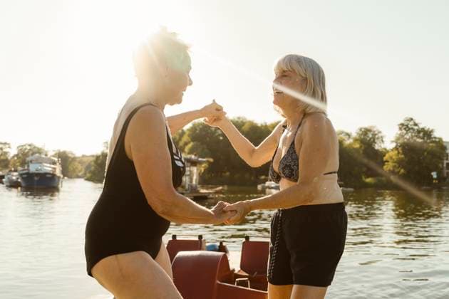 Happy senior female friends holding hands and dancing on houseboat during vacation Germany, Berlin, model released, property released Copyright: xMaskotx , MA108717 MA108717