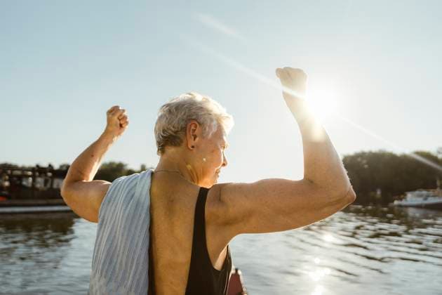 Senior woman flexing muscles on houseboat during vacation at sunny day Germany, Berlin, model released, property released Copyright: xMaskotx , MA108720 MA108720