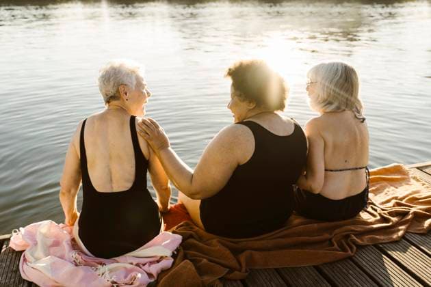 Happy elderly female friends talking while sitting on houseboat near lake on vacation Germany, Berlin, model released, property released Copyright: xMaskotx , MA108725 MA108725