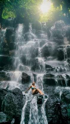 Creative Highlights Symbolbilder MR_ID20011_16553_MariaEugeniaMendezRodriguez.jpg An overjoyed woman sitting majestic Balinese waterfall, surrounded by lush greenery and the raw beauty of nature Model Released GabrielTrujillo_ID20011_592429_027 Copyright: xGabrielxTrujillox
