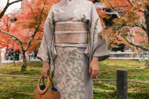 Creative Highlights Symbolbilder A person in a subtle floral kimono holding a wicker basket amidst vibrant autumn leaves, evoking the tranquility of Japan s fall season Model Released GerardMoral_ID20499_605596_025 Copyright: xGerardxMoralx