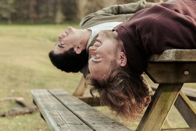 Creative Highlights Symbolbilder Upside-down view of a gay couple laughing together while lying back on a picnic bench, enjoying a playful moment in an outdoor setting Model Released HodeiUnzueta_ID20740_612257_021 Copyright: xHodeixUnzuetax