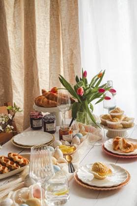 IMAGO Creative, Ostern, Bräuche, Osterbrunch A festive Easter breakfast spread featuring croissants, coconut muffins, waffles, and colorful jams on a beautifully arranged table with spring flowers and Easter eggs Model Released JoannaFufal_ID20588_608221_001 Copyright: xJoannaxFufalx