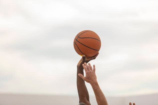 Creative Highlights Symbolbilder A basketball held steady in the hand of a player against a soft-focus background, ready for action on the outdoor court Model Released JuanAizpuru_ID20351_602374_013 Copyright: xJuanxAizpurux