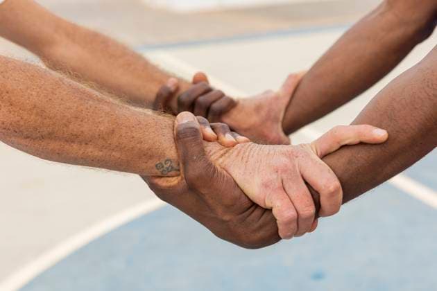Creative Highlights Symbolbilder Close-up of multiethnic basketball players hands gripping each other in a circle, displaying a powerful symbol of team commitment and trust Model Released JuanAizpuru_ID20351_602408_015 Copyright: xJuanxAizpurux