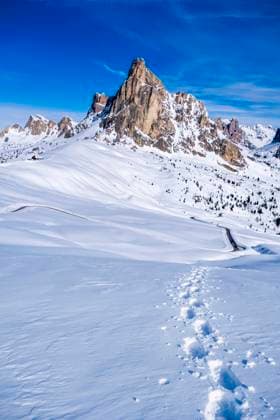 Snow-covered slopes of alpine Dolomite landscape around Giau pass in winter, the summit of Ra Gusela in the distance. Cortina d˜Ampezzo Veneto Italy FB_2024_1028