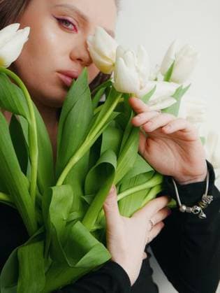 Creative Highlights Symbolbilder A pregnant woman with a hairstyle and makeup on her face in a black tight dress with white tulips 23739021 ,model released, Symbolfoto RECORD DATE NOT STATED