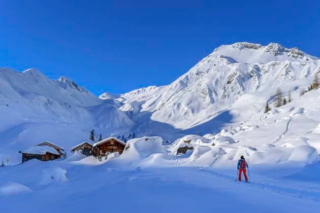 Woman back country skiing towards cottage under snow at Junsjoch, Tux Alps, Tyrol, Austria model released, Symbolfoto, ANSF00845