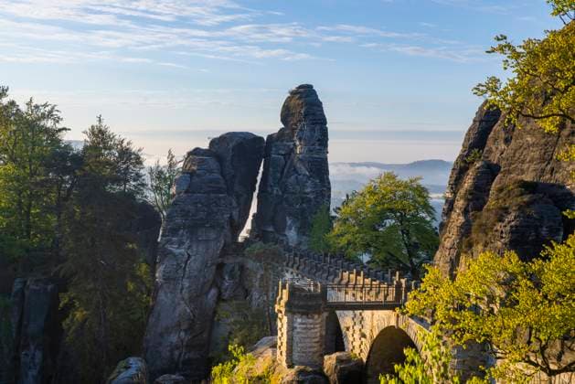 Sonnenaufgang in der Sächsischen Schweiz Die Bastei ist eine Felsformation mit Aussichtsplattform in der Sächsischen Schweiz am rechten Ufer der Elbe auf dem Gebiet der Gemeinde Lohmen zwischen dem Kurort Rathen und Stadt Wehlen. Sie zählt zu den meistbesuchten Touristenattraktionen der Sächsischen Schweiz. .Ferdinandaussicht mit Blick auf die Basteibrücke von 1851. Rathen Sachsen Deutschland *** Sunrise in Saxon Switzerland The Bastei is a rock formation with a viewing platform in Saxon Switzerland on the right bank of the Elbe in the municipality of Lohmen between the spa town of Rathen and the town of Wehlen It is one of the most visited tourist attractions in Saxon Switzerland Ferdinand view with a view of the Bastei Bridge from