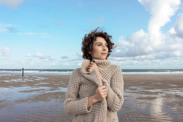 Beautiful woman wearing cardigan sweater standing at beach model released, Symbolfoto, KNSF10191
