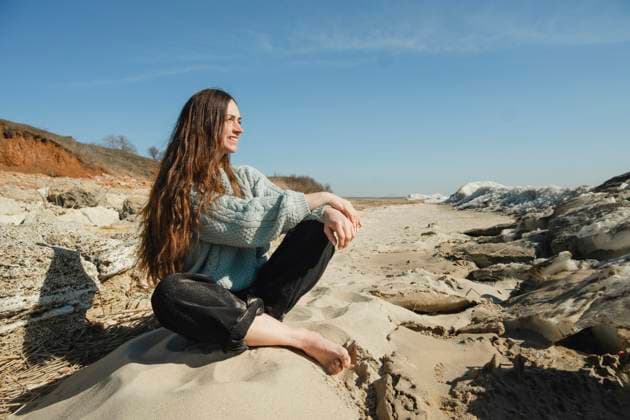 Smiling woman sitting on rock at sunny day model released, Symbolfoto, KVBF00068