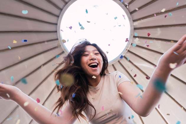 Creative Highlights Symbolbilder Cheerful woman playing with colorful confetti under canopy model released, Symbolfoto, PNAF06207