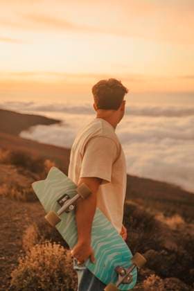 Creative Highlights Symbolbilder Man with skateboard looking at clouds in El Teide National Park model released, Symbolfoto, ACPF01583
