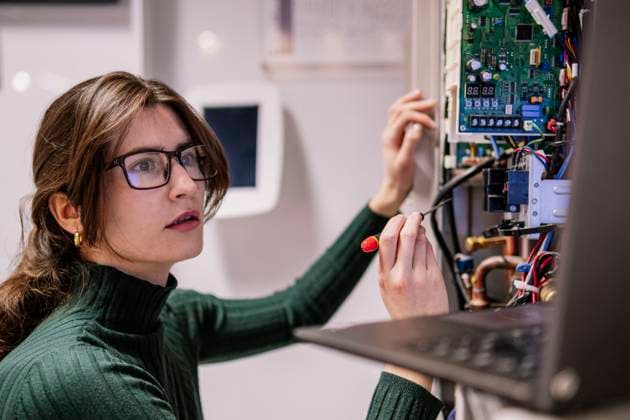 Engineer looking at laptop and fixing network server in office model released, Symbolfoto property released, AMWF02191