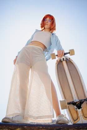 Creative Highlights Symbolbilder Young woman posing with skateboard under sky model released, Symbolfoto, EGCF00105