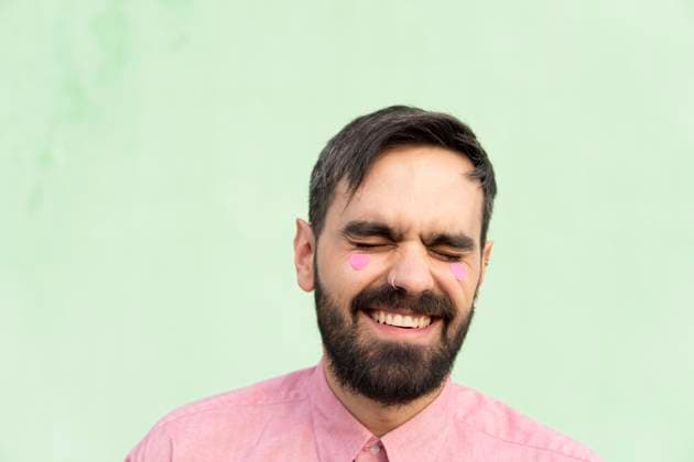 Creative Highlights Symbolbilder Cheerful man with pink heart shape stickers against mint green background model released, Symbolfoto, MGRF01252