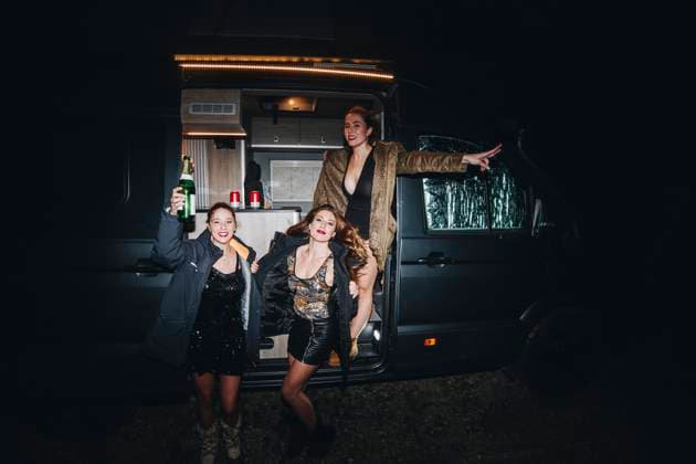 Creative Highlights Symbolbilder Happy women celebrating New Year s eve with champagne bottle outside motor home at night model released, Symbolfoto, MRRF02755