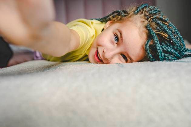 Creative Highlights Symbolbilder Smiling girl with turquoise dyed braided hair lying on bed taking selfie at home model released, Symbolfoto property released, OLRF00254