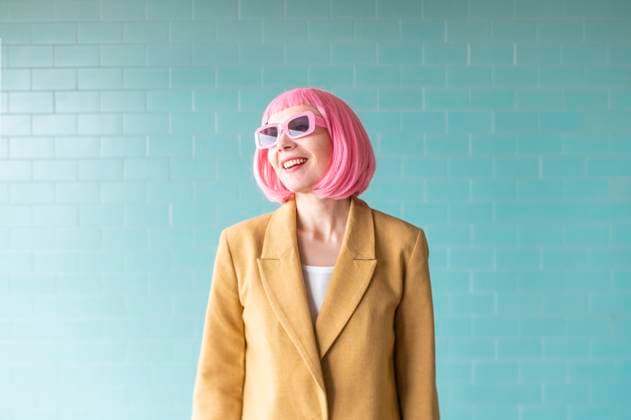 Creative Highlights Symbolbilder Smiling woman with sunglasses standing near turquoise wall model released, Symbolfoto, VRAF00501