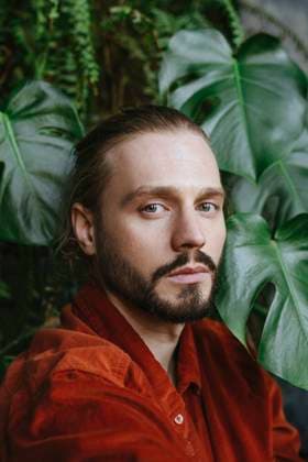 Creative Highlights Symbolbilder Man wearing red shirt near monstera leaves model released, Symbolfoto property released, YTF02191