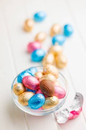 Easter chocolate eggs wrapped in aluminium foil in bowl on white table. Easter chocolate eggs wrapped in aluminium foil in bowl on the white table. Copyright: xZoonar.com JirixHERAx 21370810