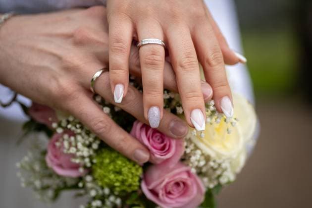 Verlobung und Liebe: Hände einer Braut , Deutschland, 24.04.2024, Das Bild zeigt die Hände einer Person, die sorgfältig manikürte Nägel und zwei Ringe, einen Ehering und einen Verlobungsring, zur Schau stellt, während sie einen Brautstrauß hält. *** Engagement and love Hands of a bride , Germany, 24 04 2024, The picture shows the hands of a person showing off carefully manicured nails and two rings, a wedding ring and an engagement ring, while holding a bridal bouquet