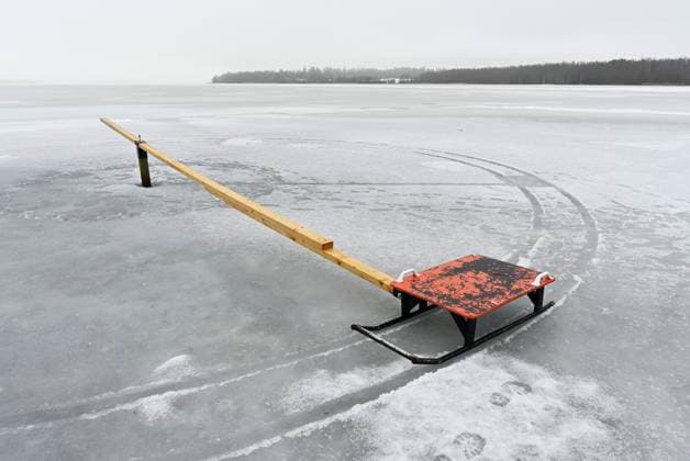IMAGO Creative, Winter, Auf dem Land Frozen lake wih red sleigh and wtooden plank A desolate frozen lake with a solitary red sleigh attached to a long wooden plank, creating a stark contrast Copyright: xZoonar.com MikhailxOlykaynenx 21381475