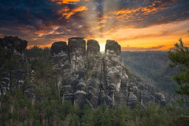 Rugged rocks at Basteibridge at sunset. Wide view over trees and mountains. Rugged rocks at Basteibridge at sunset. Wide view over trees and mountains. National park in Germany Copyright: xZoonar.com MartinxKöbschx 21396928