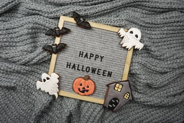 The text is written in the frame - Happy Halloween and there are gingerbread cookies The text is written in the frame - Happy Halloween and there are gingerbread cookies. Gingerbread cookies for Halloween. Knitted gray background for Halloween. Copyright: x RECORD DATE NOT STATED