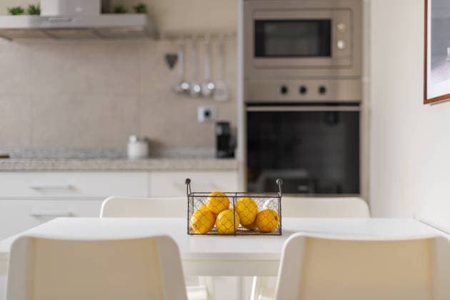 Metal basket with ripe yellow lemons on a white dining table. Blurred background of kitchen furniture and electronic equipment made of brushed durable metal along the wall. Metal basket with ripe yellow lemons on a white dining table. Blurred background of kitchen furniture and electronic equipment made of brushed durable metal along the wall Copyright: xPavelxAdashkevich RECORD DATE NOT STATED