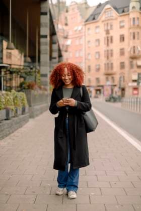 Creative Highlights Symbolbilder Full length of smiling businesswoman using smart phone while walking on sidewalk in city Sweden, Stockholm, model released Copyright: xMaskotx , MA108997 MA108997