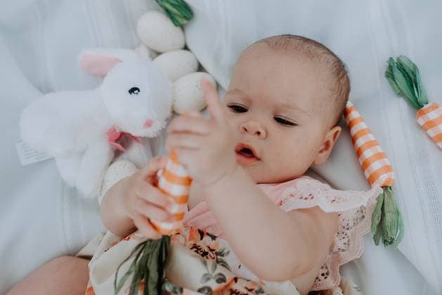 Baby girl explores with wonder amidst Easter toys Louisville, Kentucky, United States CR_ZXOF240429E-1416049-01 ,model released, Symbolfoto