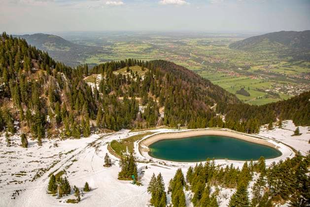 Blick auf den Speichersee Garland am Berg Brauneck in Lenggries ( Bayern ). Der See entstand im Jahr 2012 in einer künstlich angelegten Mulde bei der Garlandalm zwischen Brauneckschneid und Kogel und versorgt als Speichersee für die künstliche Beschneiung das Skigebiet Lenggries mit Wasser für den Skibetrieb. Lenggries *** View of the Garland reservoir on the Brauneck mountain in Lenggries Bavaria The lake was created in 2012 in an artificial basin near the Garlandalm between Brauneckschneid and Kogel and supplies the Lenggries ski area with water for artificial snowmaking for the Lenggries ski resort