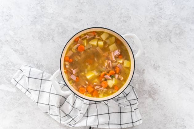 IMAGO Creative, Herbst, Wärmende Suppen und Eintöpfe Split Pea Soup Flat lay. Cooking split pea soup in enameled cast iron dutch oven. Copyright: xArinaxHabich RECORD DATE NOT STATED