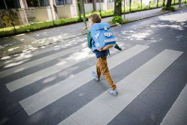 Symbolfoto zum Thema Schulkind im Strassenverkehr. Ein sechsjaehriger Junge laeuft mit seinem Schulranzen auf dem Ruecken ueber den Zebrastreifen eines Fussgaengerueberweges vor einer Grundschule. Berlin, 08.05.2024. Berlin Deutschland *** Symbolic photo of a schoolchild in traffic A six-year-old boy walks with his satchel on his back across a pedestrian crosswalk in front of an elementary school Berlin, 08 05 2024 Berlin Germany Copyright: xThomasxTrutschelxphotothek.dex