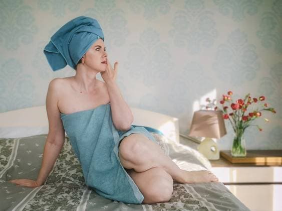 Creative Highlights Symbolbilder A woman wrapped in a towel sits on the bed after taking a bath Vilnius, Vilnius County, Lithuania R_EDSAHG211119-865553-01 ,model released, Symbolfoto